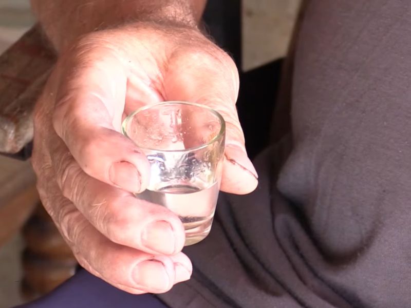 čovek drži čašicu sa rakijom u ruci