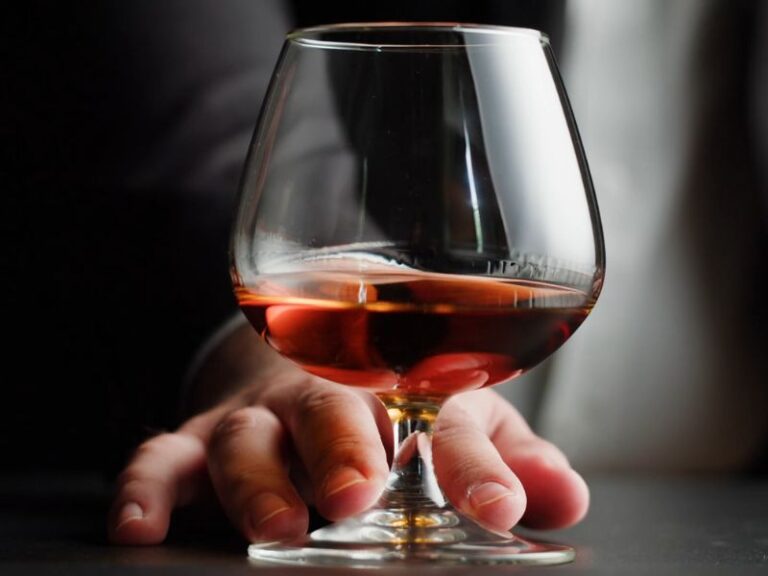 momak drži rakiju između prstiju u ruci