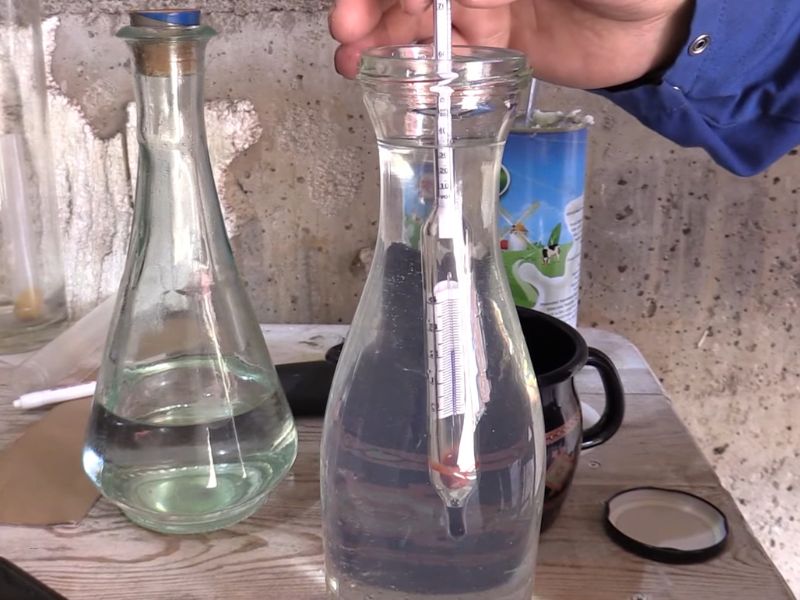 čovek meša rakiju sa vodom kako bi je razblažio