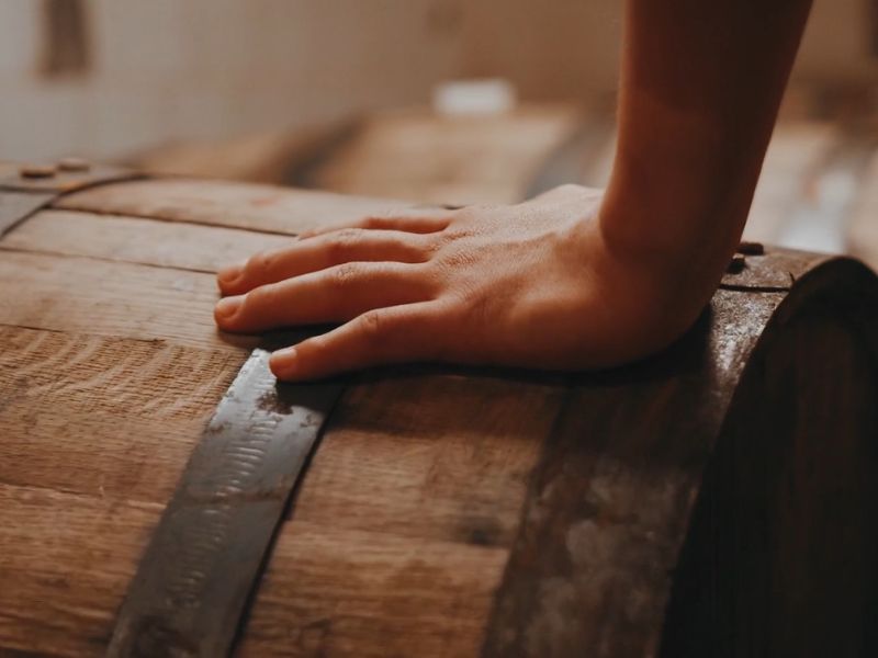 osoba drži ruku na buretu za rakiju